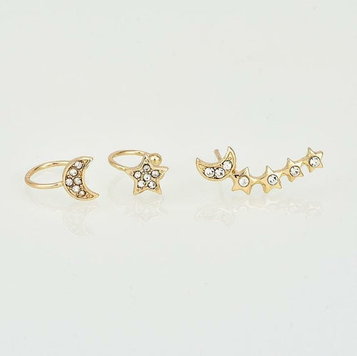Set of gold rings with star, moon, and crystal designs on a light gray background