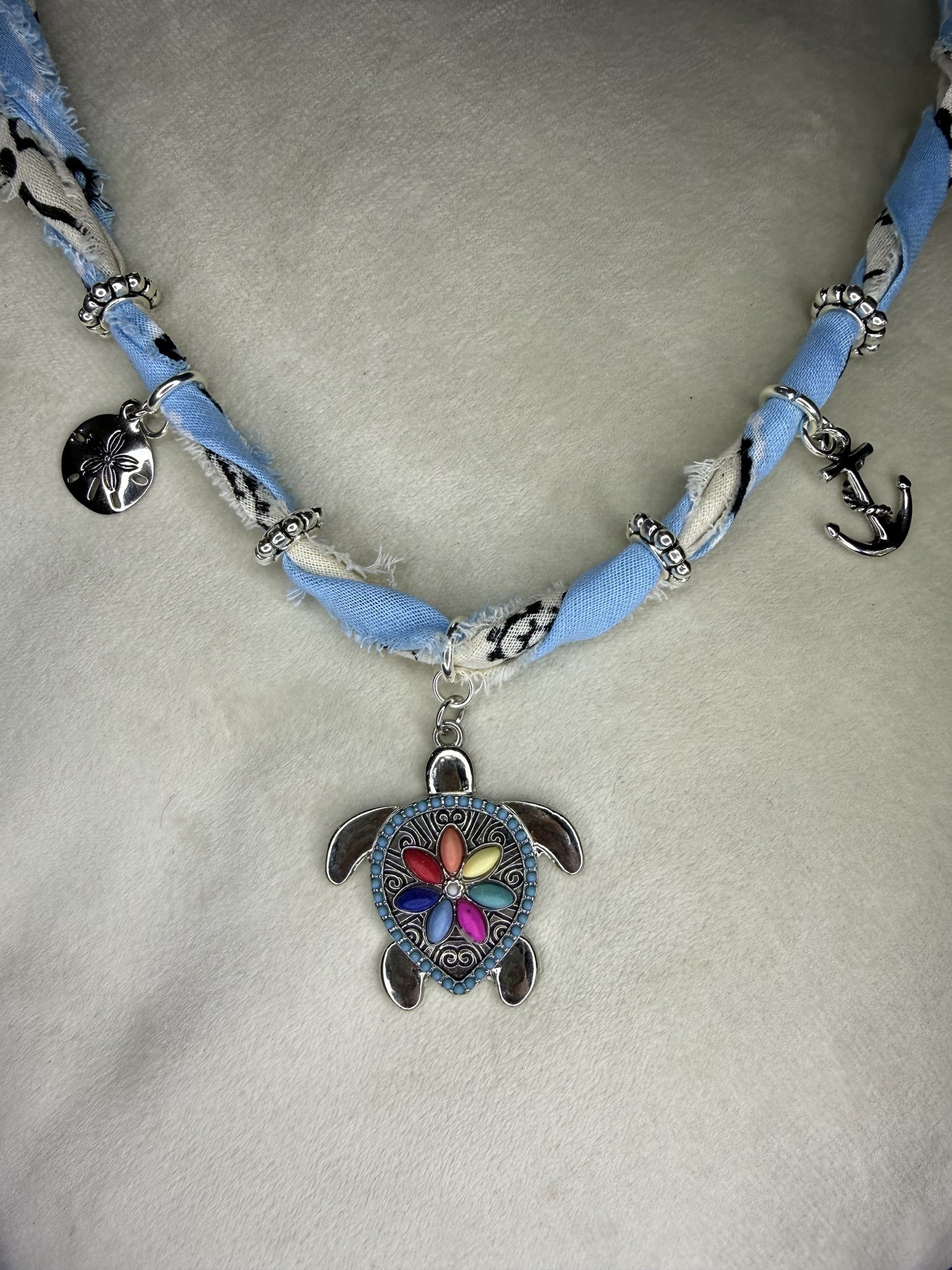 Necklace with a turtle pendant on a light gray background