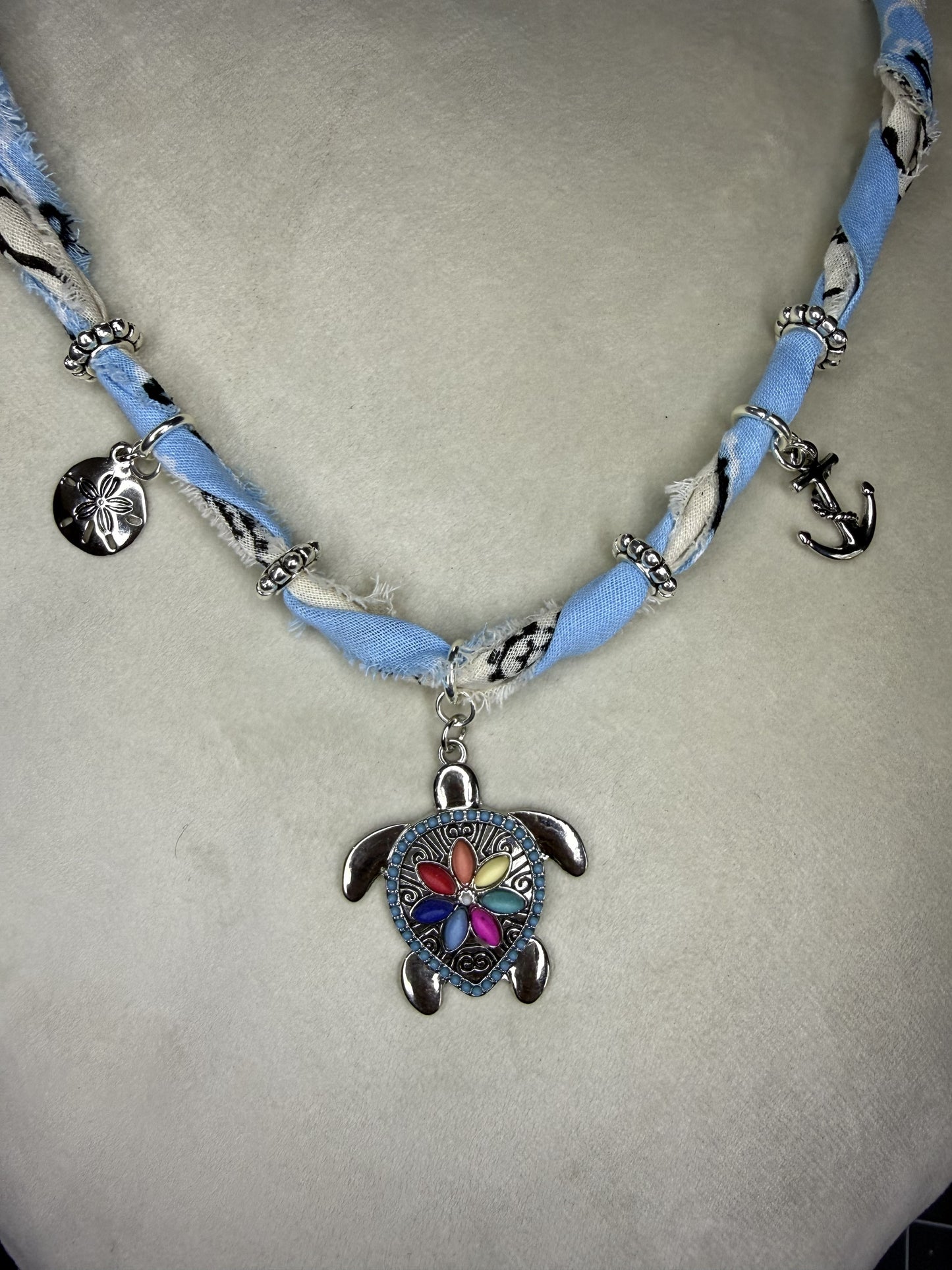 Necklace with a turtle pendant on a light gray background