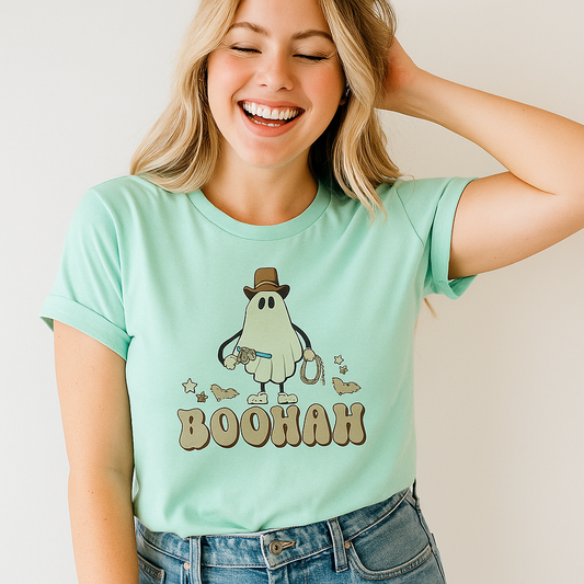 Woman wearing a light blue t-shirt with a cartoon character and 'BOOHAH' text, smiling against a plain background.