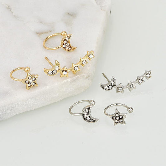 Set of gold and silver hoop earrings with star and moon designs on a marble surface.